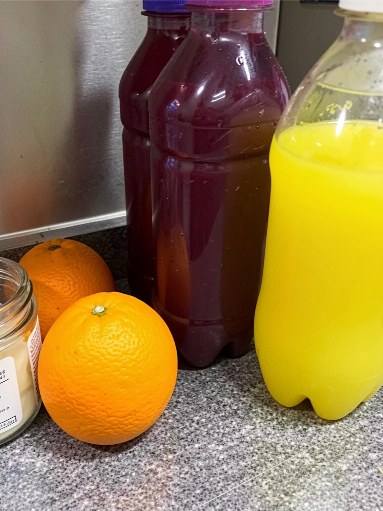 Tábua de corte com frutas inteiras e cascas separadas, faca ao lado.